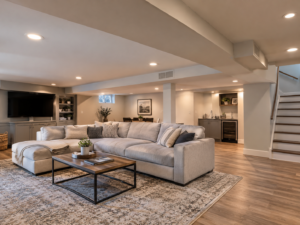 Finished basement with a low ceiling, integrated soffits, HVAC ductwork, recessed lighting, and a comfortable modern living area.